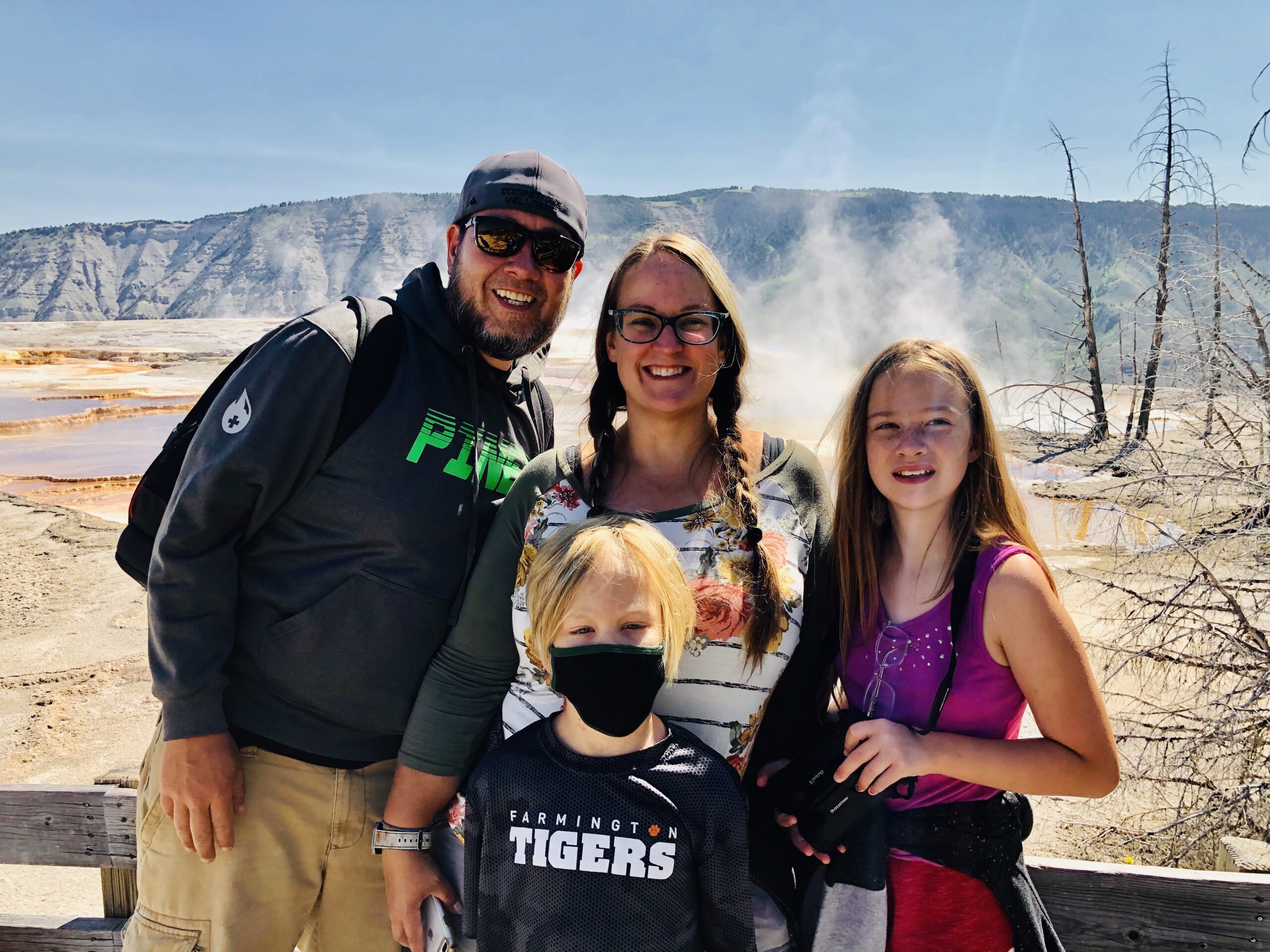 Family posed in front of a geyser at mammoth hot springs in yellowstone national park