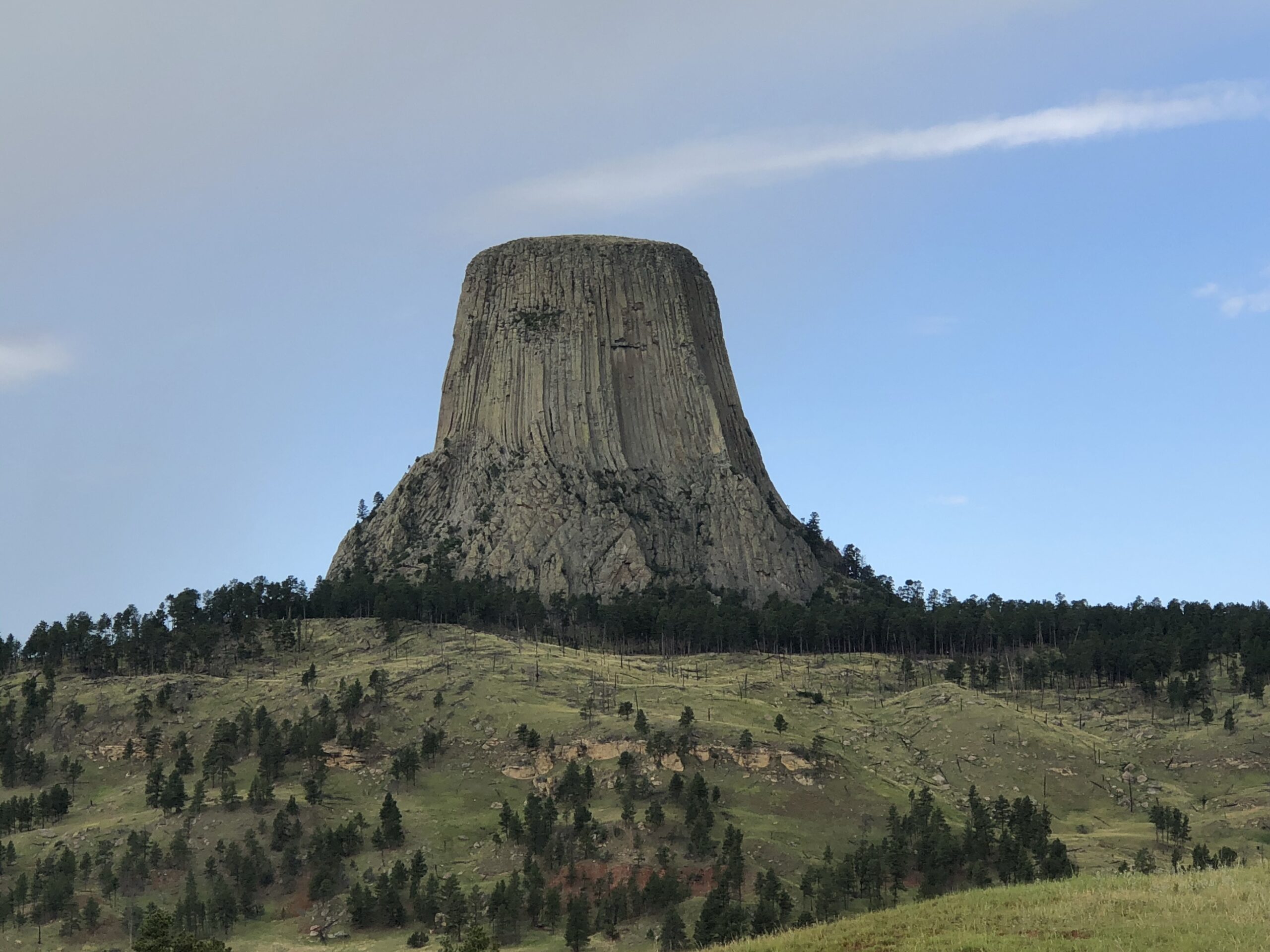 Devils Tower National Monument is a columnar rock structure that rises up above the flatter land surrounding it.