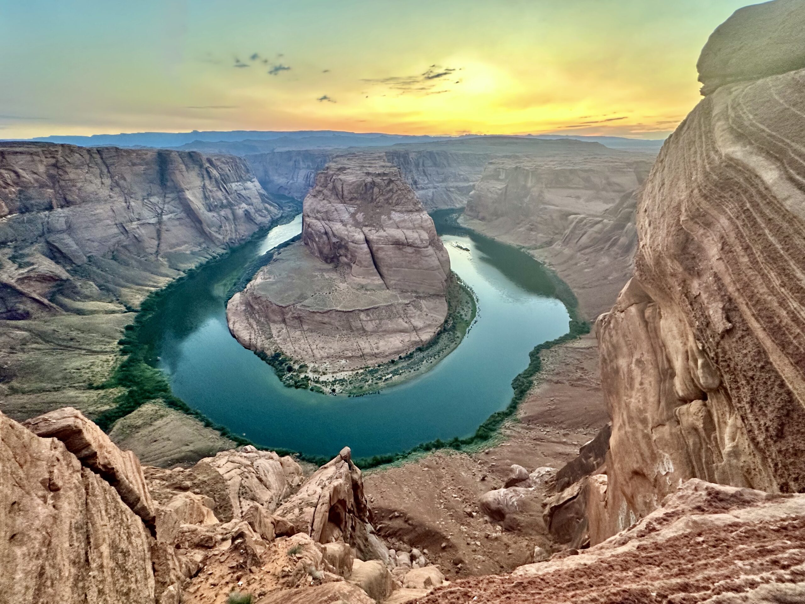 Overlooking a horseshoe shaped canyon landscape with a river at the bottom of the canyon